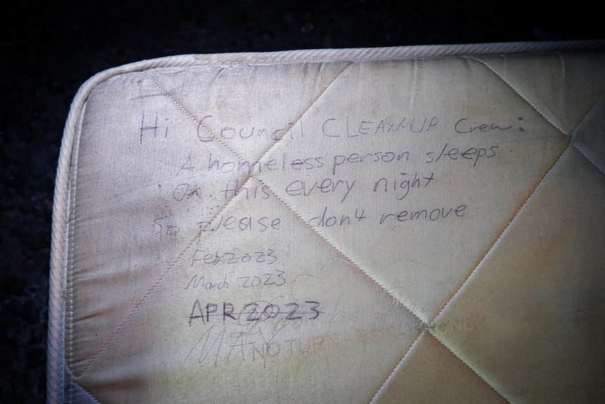 A mattress with writing telling council rubbish collectors that a homeless man is using it, and not to remove the mattress