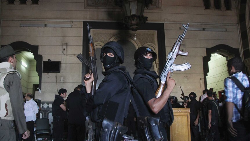 Policemen stand guard inside a room of the Al-Fath mosque in Cairo.