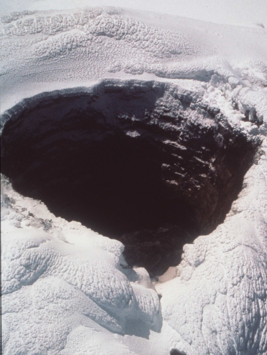 A deep crater in the ice seen from above