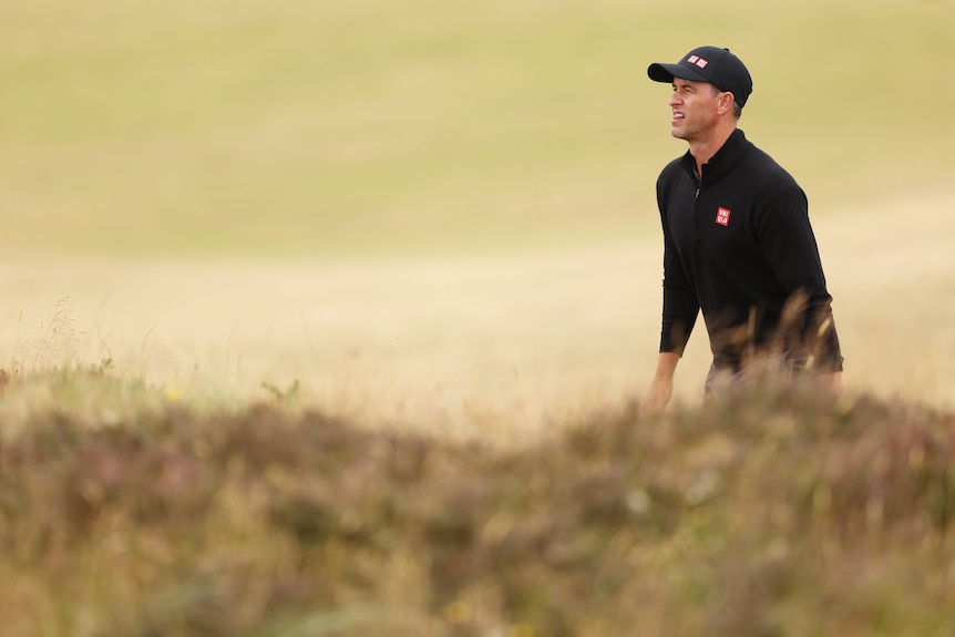 Australian golfer Adam Scott looks further down the hole as he stands behind a mound of grass and rough at The Open.