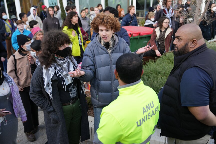 protesters speak with security guards 