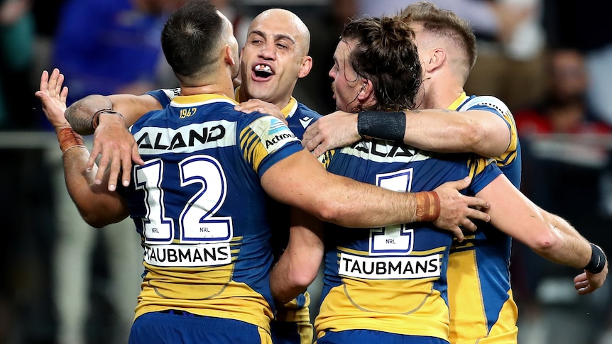 Four Parramatta Eels congregate for a group hug in celebration