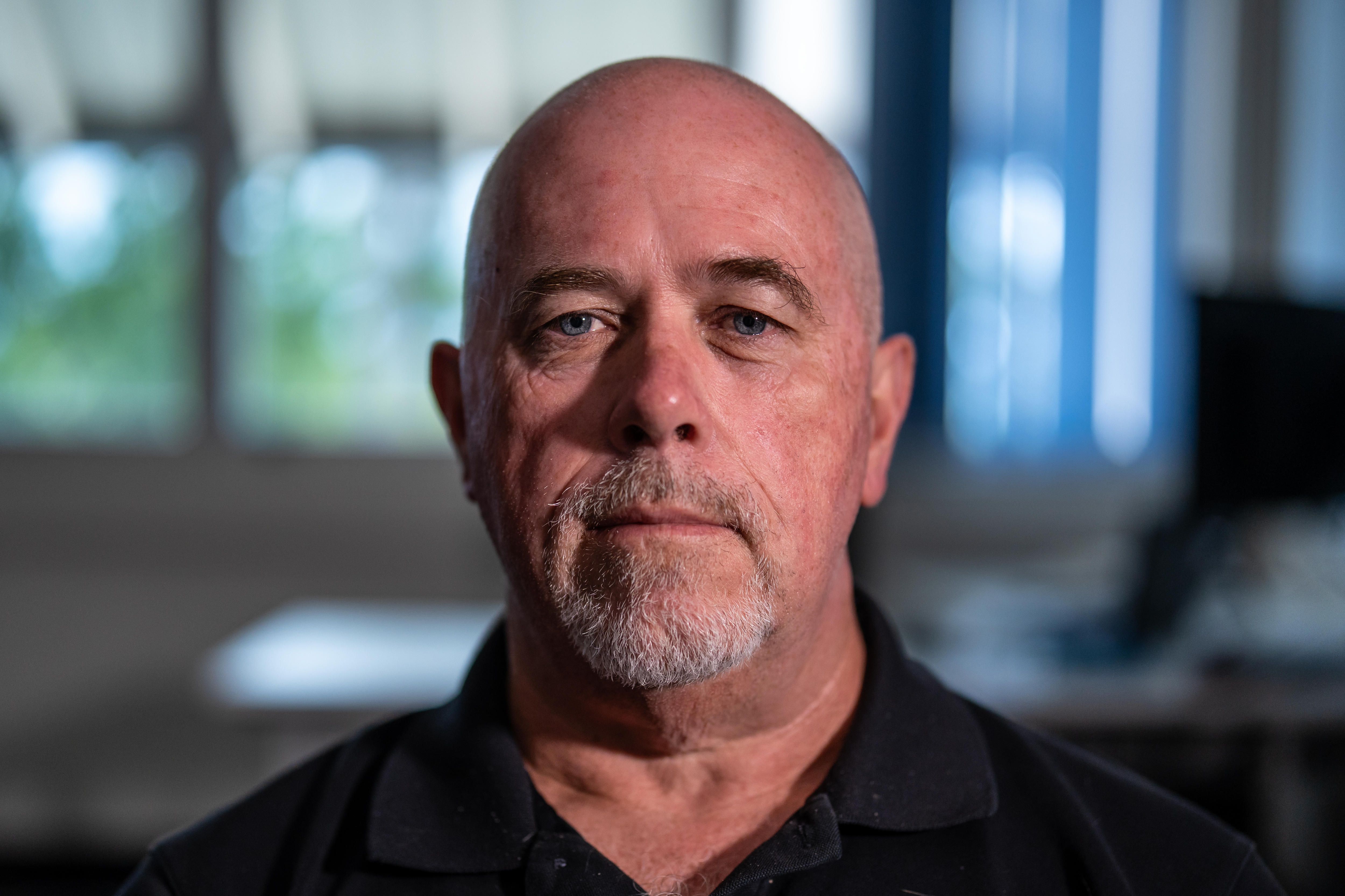 A man, serious, 40s, staring down camera.