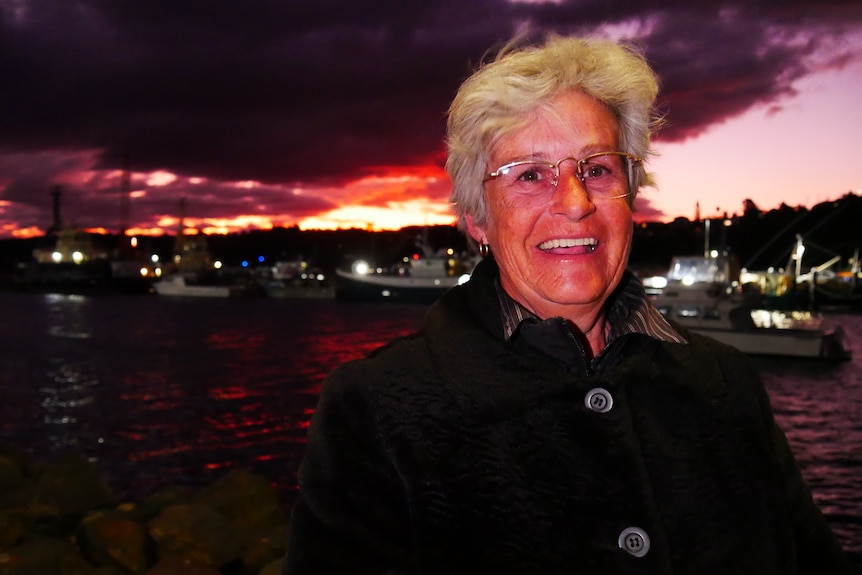 Joanne Korner smiles at the camera with a sunset in the background