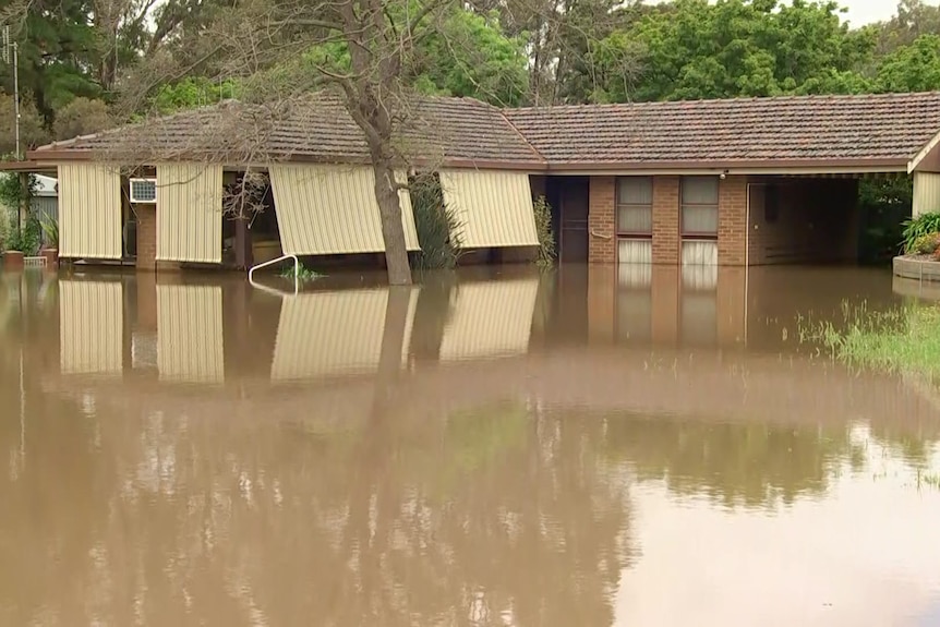 Flood waters reach about a quarter of hte way up a brick house. 