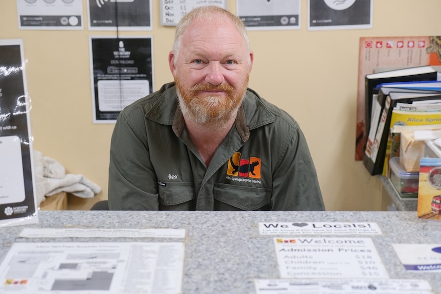 Rex Neindorf sits at a desk at the Alice Springs Reptile Centre.