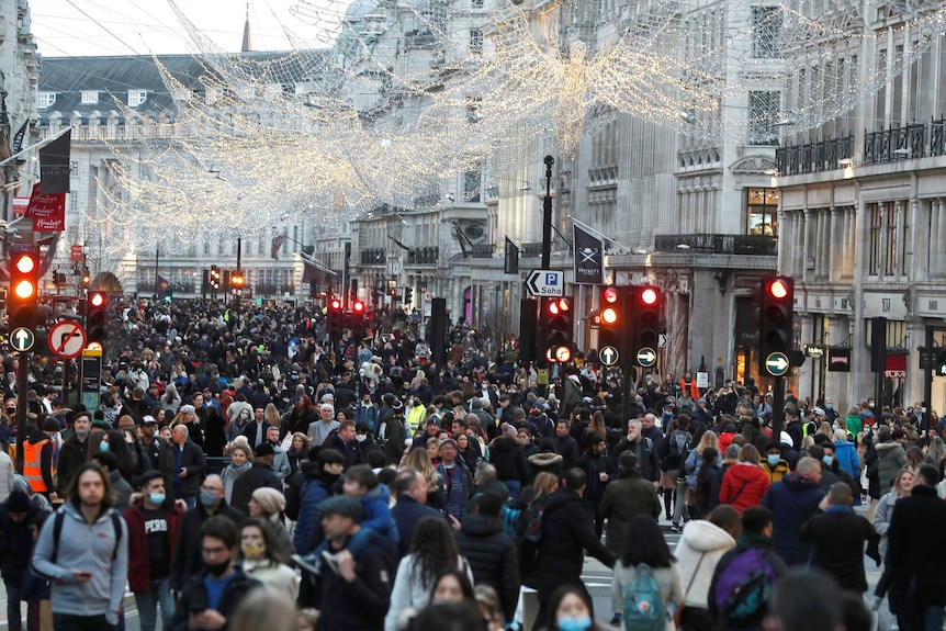 Christmas lights overhang a crowded Regent Street in London.