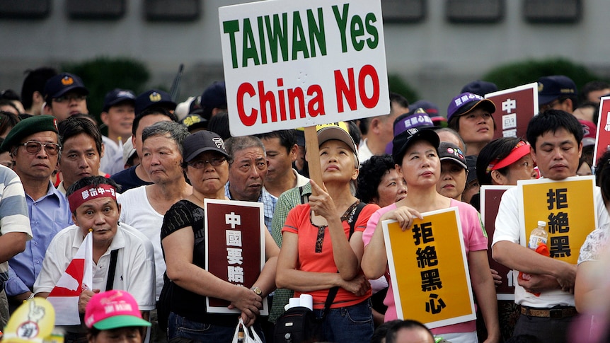 A woman holding a sign reading Taiwan yes, China no. 