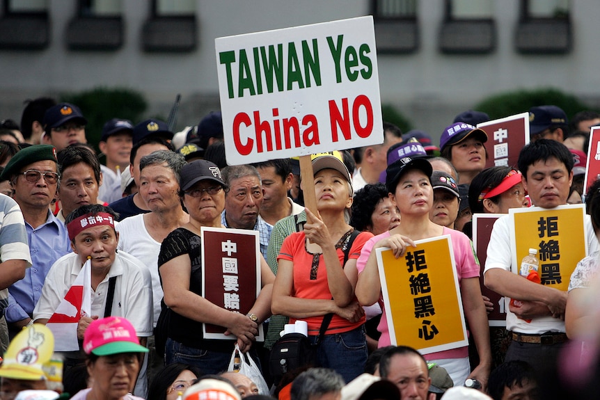 A woman holding a sign reading Taiwan yes, China no. 