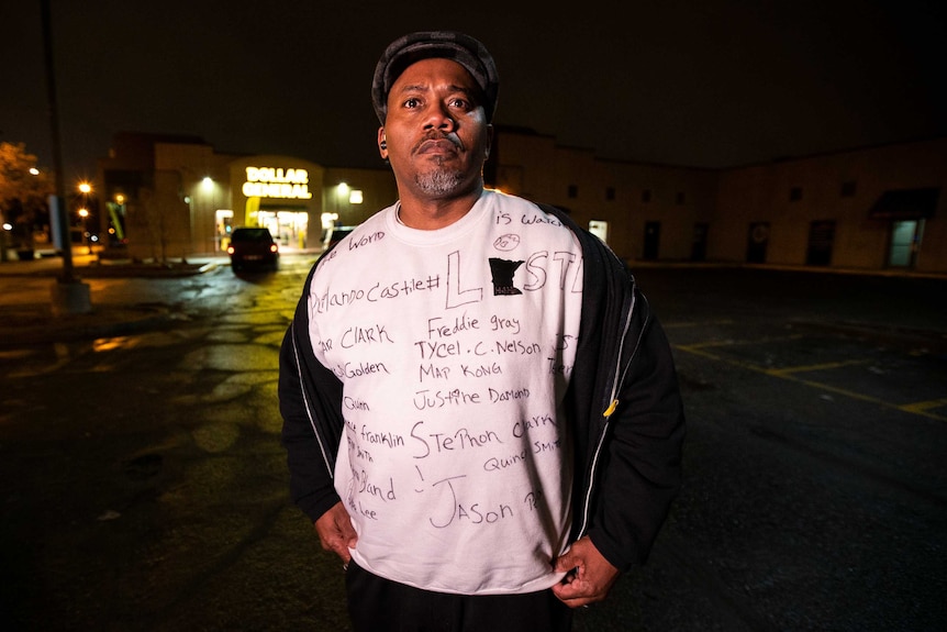 A man in a shirt bearing the names of people who have been shot dead by police in the US