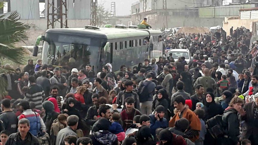 A road is crowded with Syrian civilians and their belongings as they flee the fighting