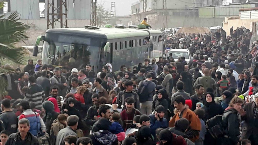 A road is crowded with Syrian civilians and their belongings as they flee the fighting