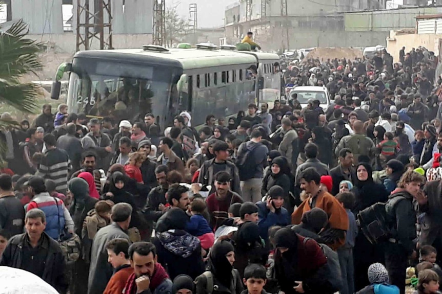 A road is crowded with Syrian civilians and their belongings as they flee the fighting