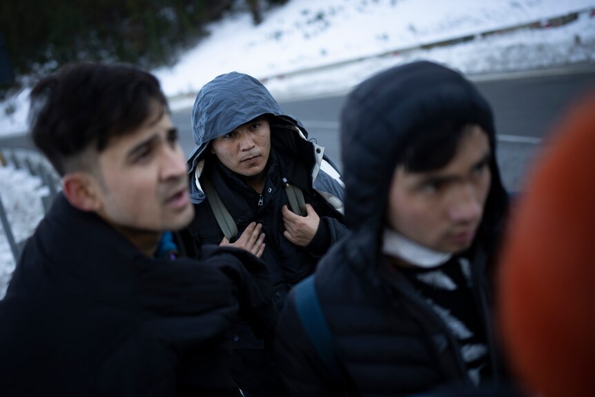 Afghan migrants headed to France from Italy walk along a mountain road.