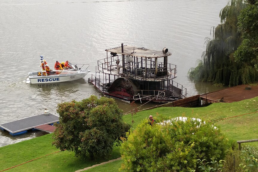 Emergency crews douse a burnt paddle steamer