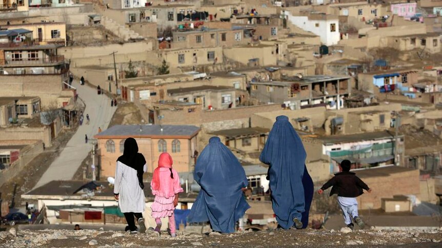 Burqa-clad women walk on Nadir Khan hilltop overlooking Kabul.