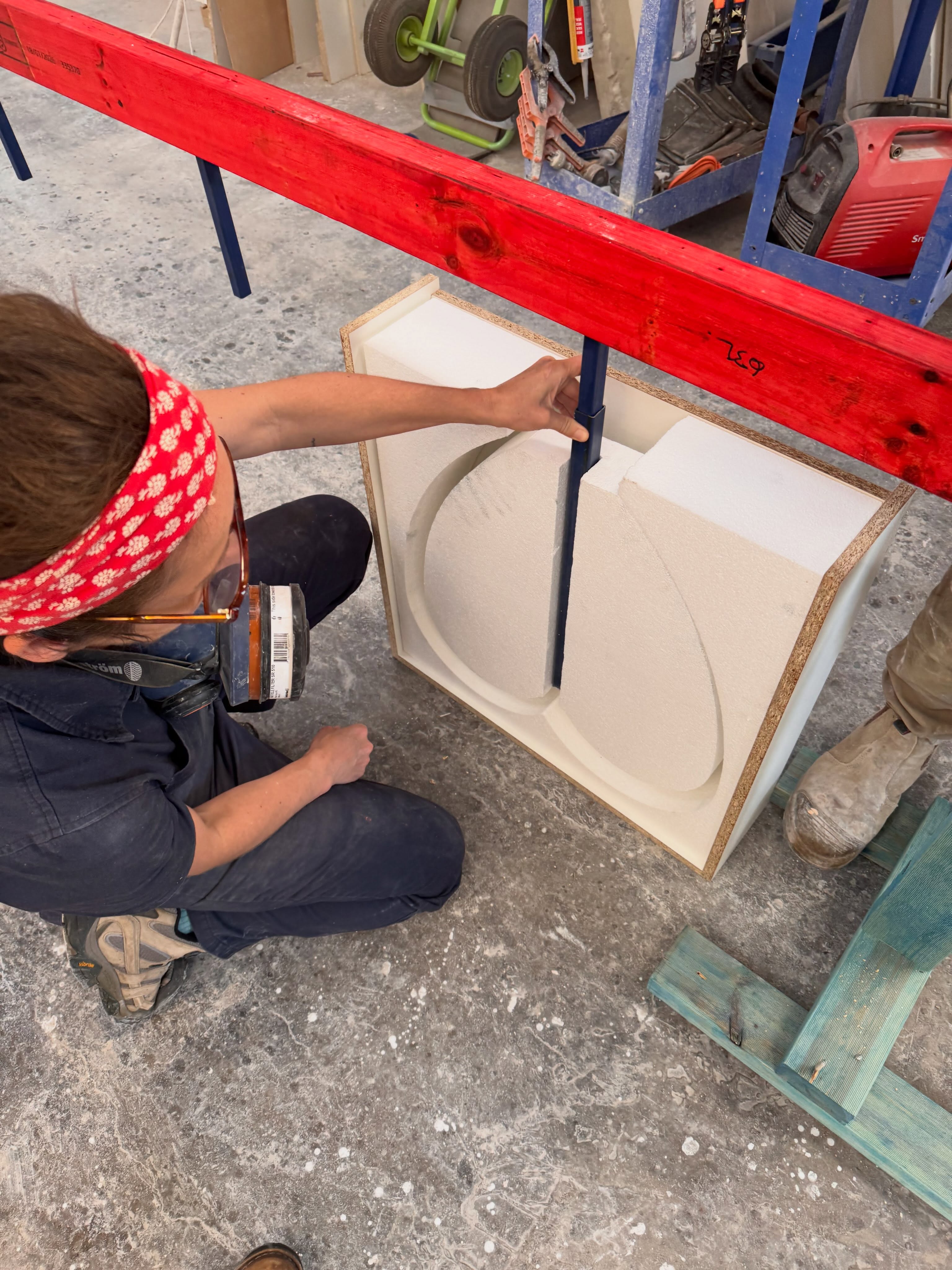 a sculture works with cement to create love hearts