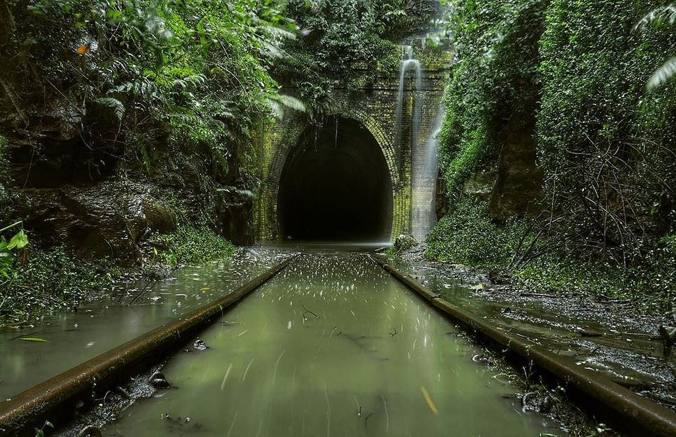 Una vía de ferrocarril a través de un túnel cubierto de agua.