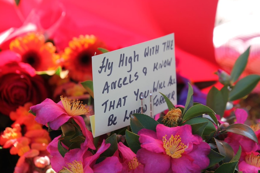 Bunch of flowers with a note a attached.