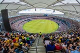 A wide shot from the top of the Perth Stadium stands showing a near-capacity crowd watching a cricket match.