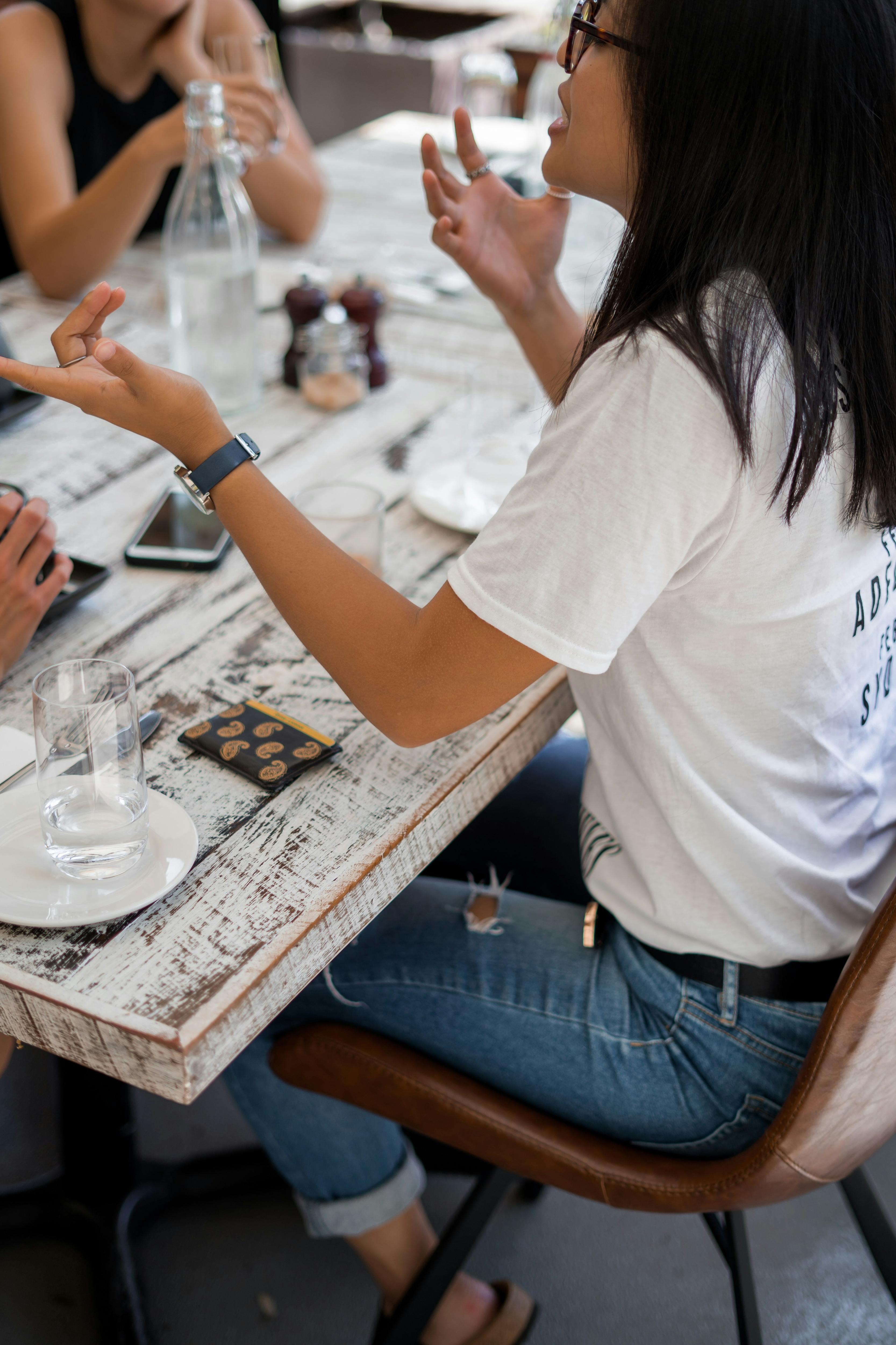 woman sitting at table talking to a small group of people