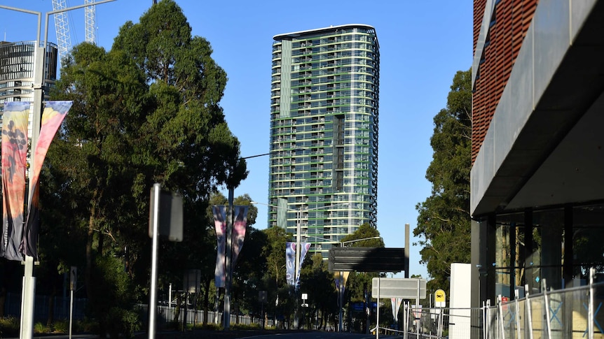 A high rise tower in the distance with a road in the foreground.