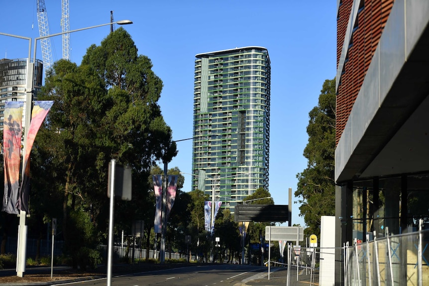 A high rise tower in the distance with a road in the foreground.