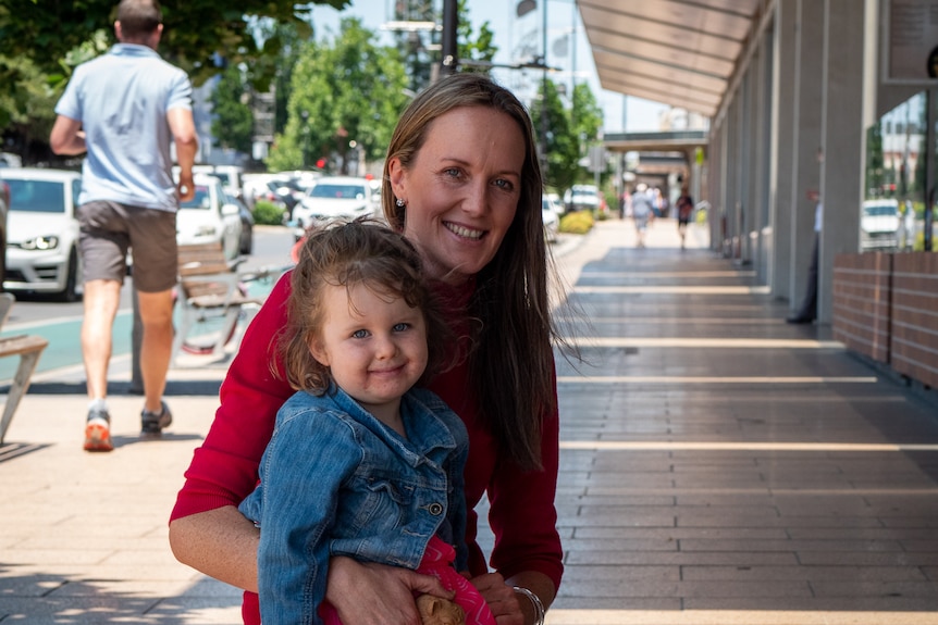 A woman and child kneel in the main street of Toowoomba