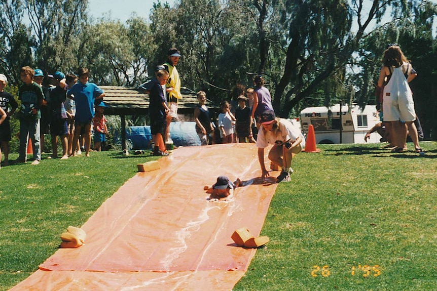 A child slides down a slip n slide in a photograph taken in 1995