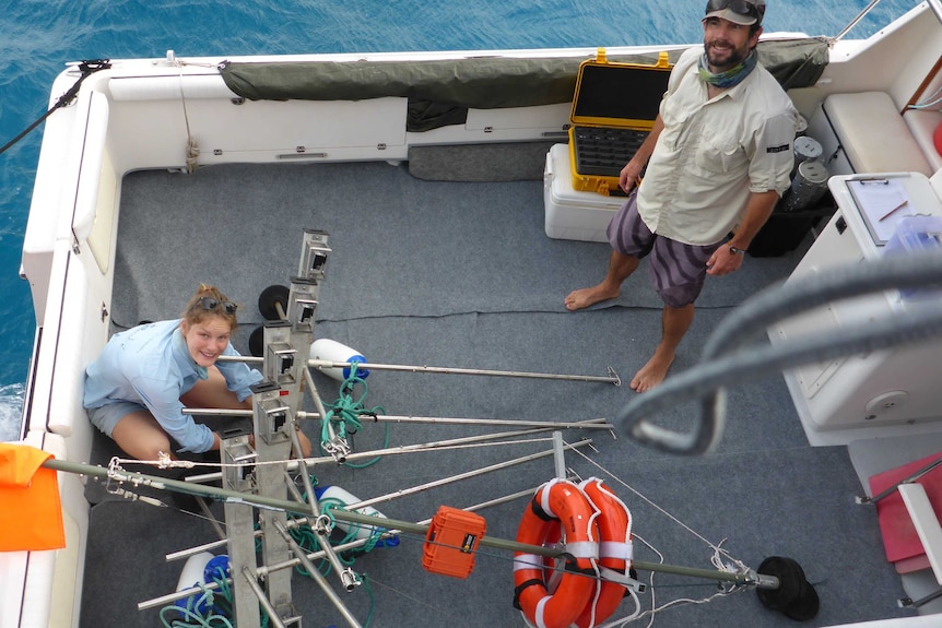 A man and a woman on the deck of a research boat.