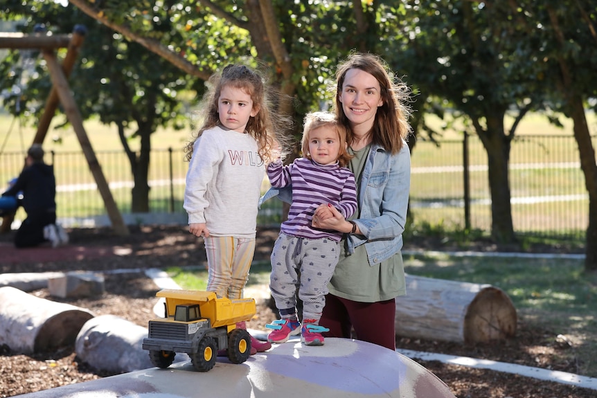 A mum with her two children plays at a local playground.