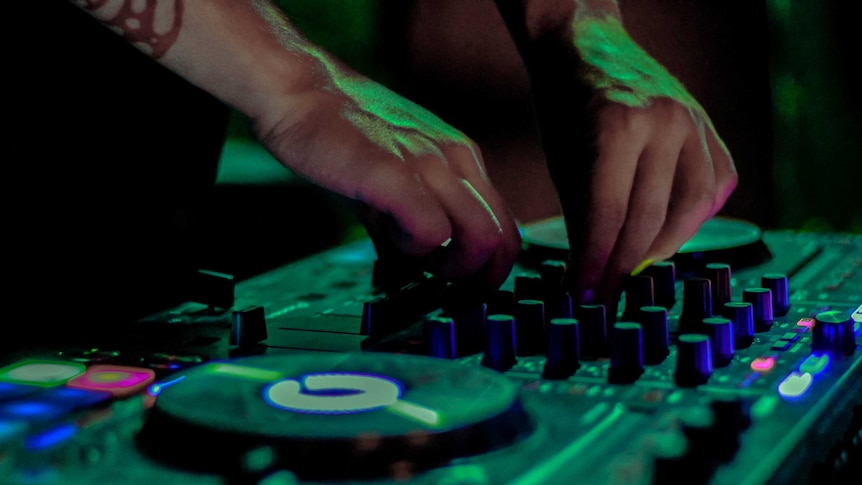 A generic image of an unidentifiable DJ using turntables in a club.