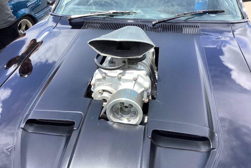 Part of an engine sticking out of a car bonnet 