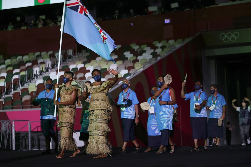 The Fijian Olympic team carry their flag.