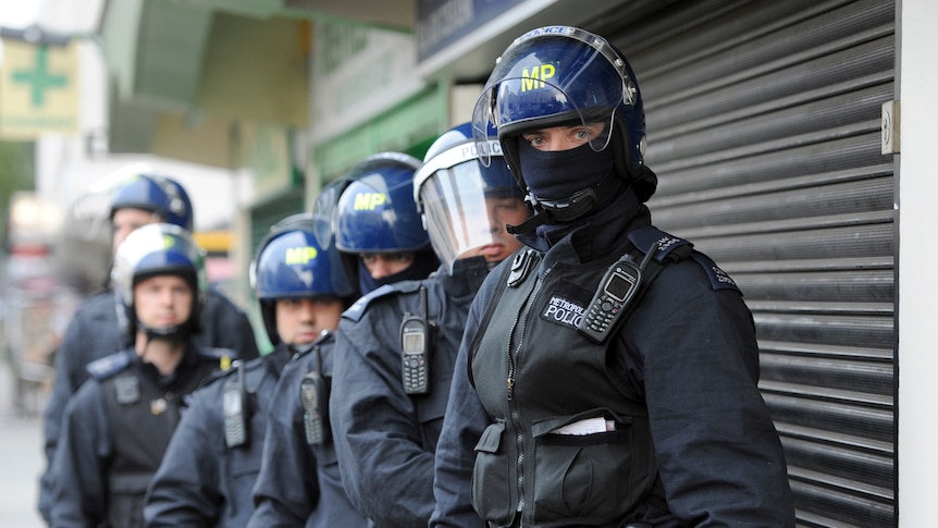 Riot police in London prepare for a raid