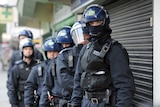Riot police in London prepare for a raid
