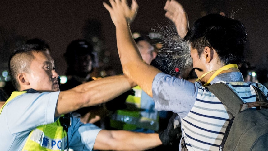 Ferguson 'don't shoot' symbolism as Hong Kong youth pepper sprayed