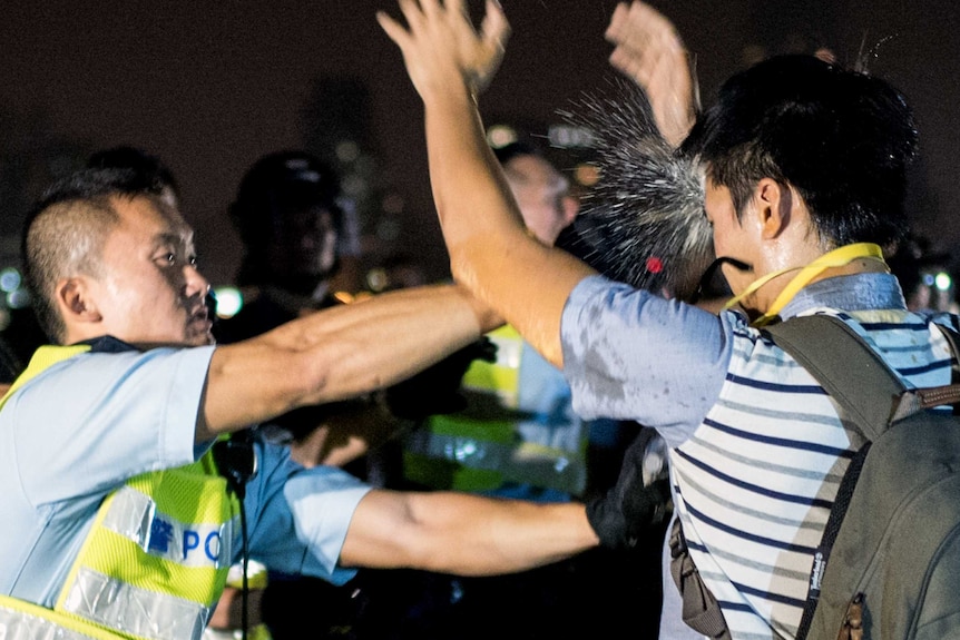 Ferguson 'don't shoot' symbolism as Hong Kong youth pepper sprayed