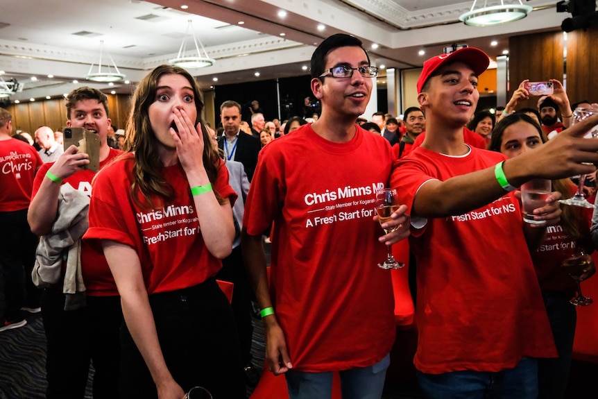 people express happiness and surprise in a hall waiting for the outcome of a vote