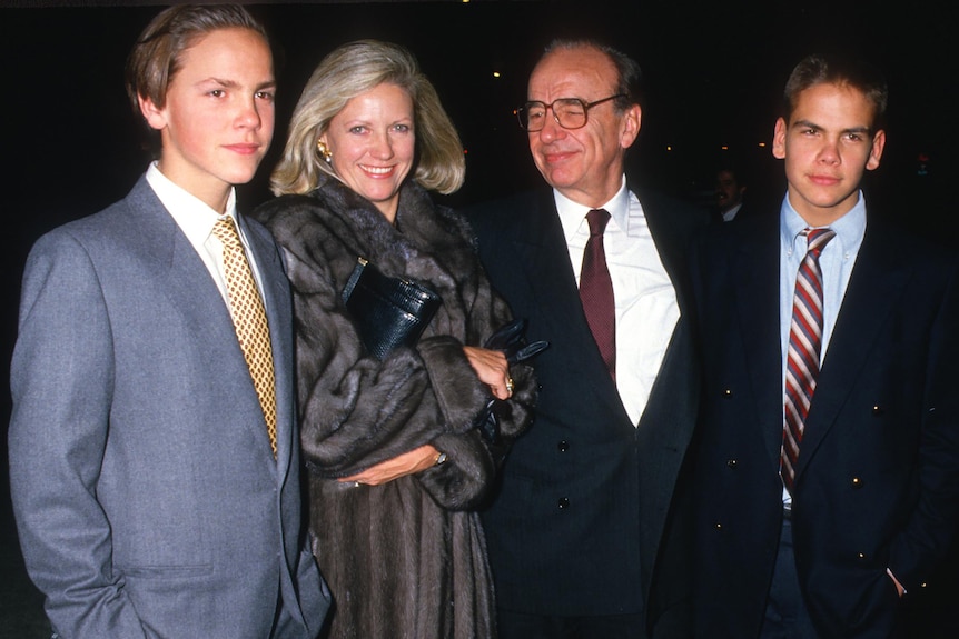 A glam blonde in a fur coat with Rupert Murdoch and two young men 