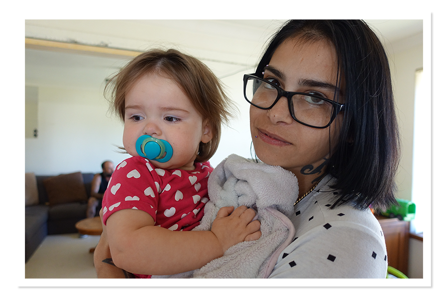 Portrait of woman with short dark hair holding baby