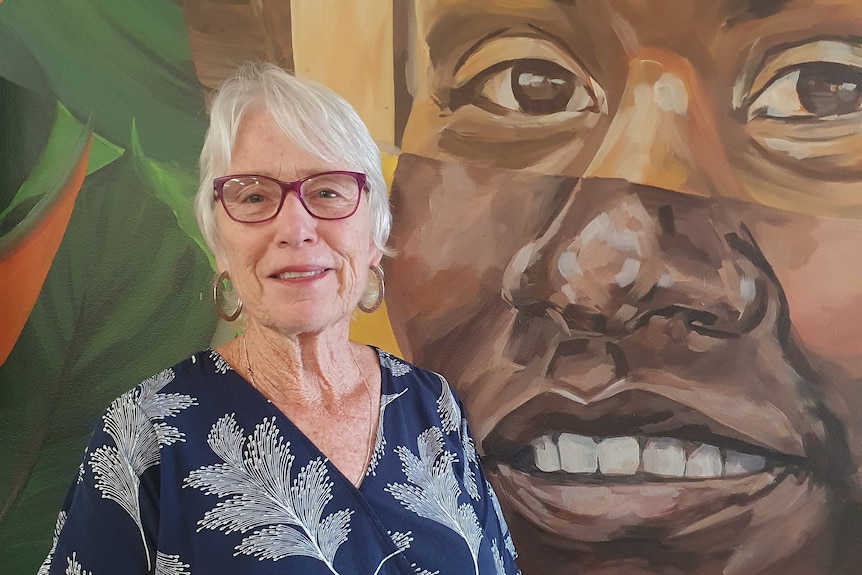 close up head shot of Gisela Hansson with colourful mural behind her