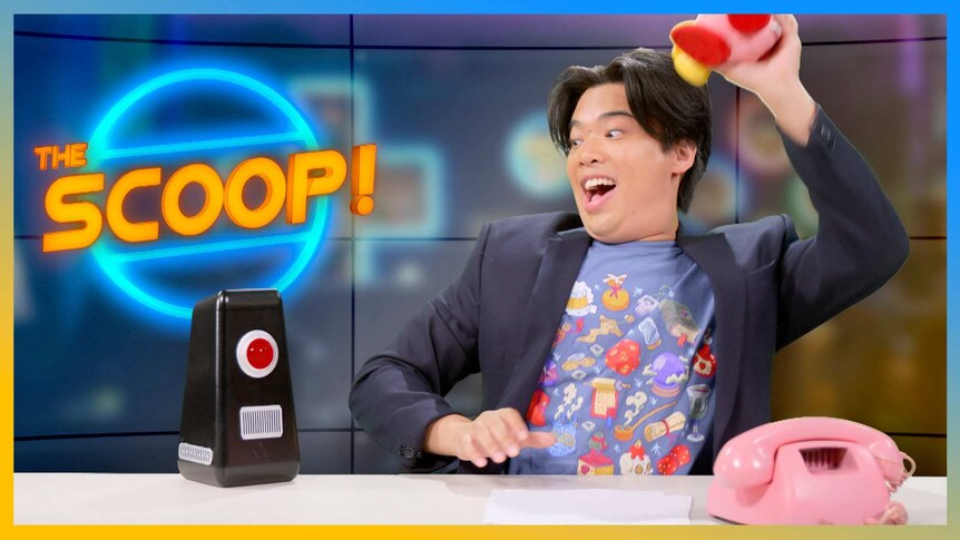 Jax holds up a plushie with the AI Bot at the Scoop desk