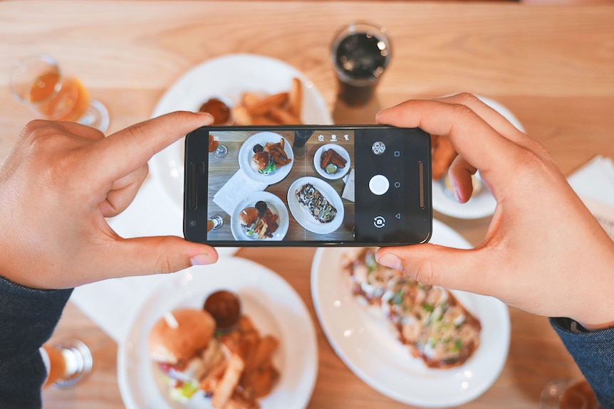 A person's hands controlling a smartphone camera.