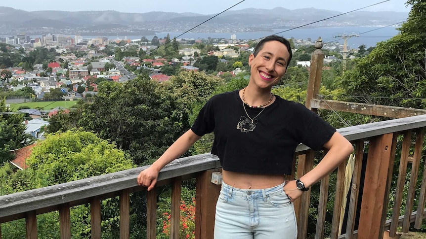 Dance teacher Alejandra Osorio Iturriaga stands on her deck with a view over Hobart spread out behind her.