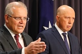 Scott Morrison points while standing alongside Peter Dutton at lecterns. An Australian flag is behind them