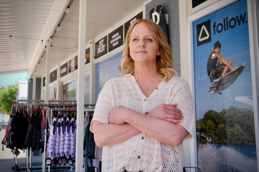 A blonde woman stands with her arms crossed outside a ski shop in Mannum.