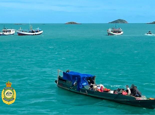 Quatro barcos de madeira azuis na água.