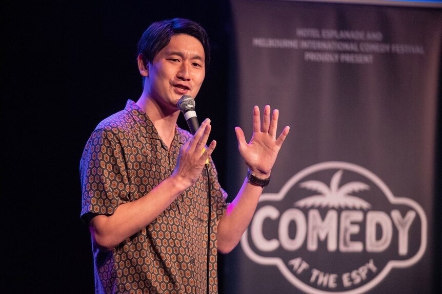 A Japanese man performs stand-up comedy.