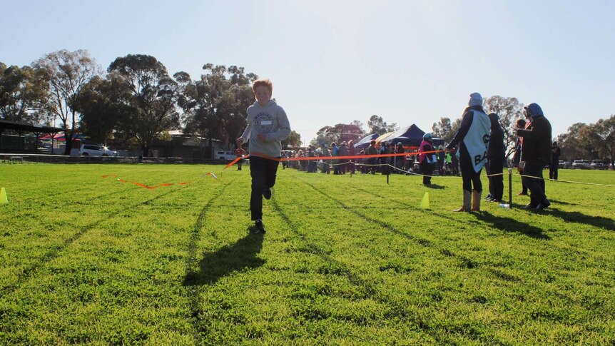 Young School of the Air student crosses the finish line at the annual athletics carnival.